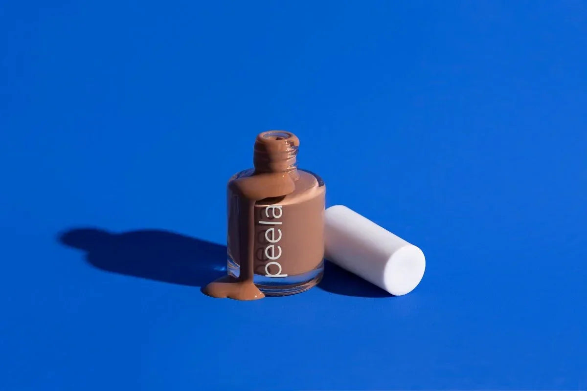 peelanails Simply Beige peelable nail polish bottle with white cap and polish spilling